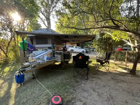 Tracker set up at a campsite with rooftop tent and awning